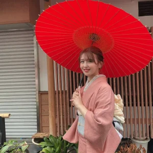 和傘をさすピンク色の着物を着た女性