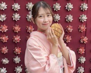 風車の壁で写真撮影するピンク色の着物を着た女性