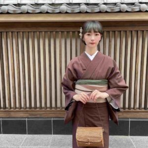 エンジ色の無地の正絹着物をかわいく着こなす女性